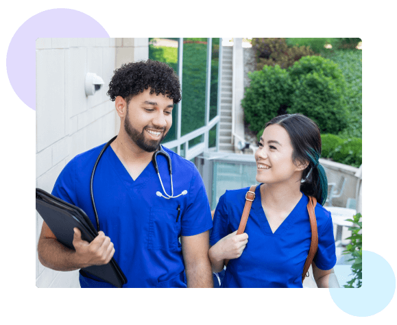 Two nursing students walking next to a building