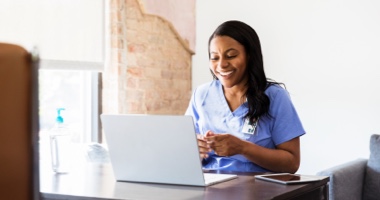Happy medical professional looking at a computer - HealthStream Clinical Development